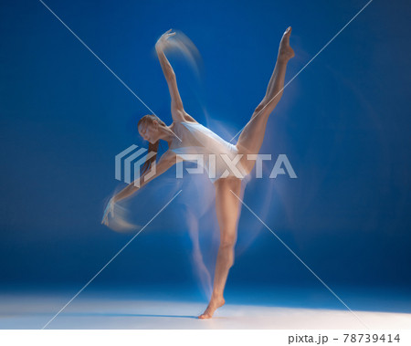 Graceful young beautiful girl, female ballet dancer dancing isolated over blue background. Reflection effect Graceful young beautiful girl, female ballet dancer dancing isolated over blue background. Reflection effect 78739414