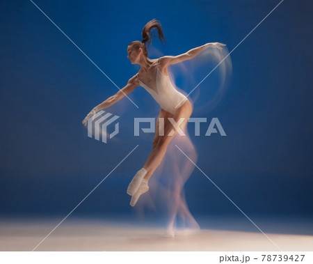 Graceful young beautiful girl, female ballet dancer dancing isolated over blue background. Reflection effect Graceful young beautiful girl, female ballet dancer dancing isolated over blue background. Reflection effect 78739427