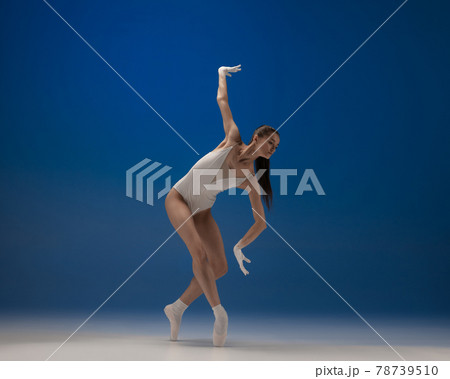 Young beautiful ballerina in action isolated over blue background. Concept of beauty, art, show, theater. 78739510