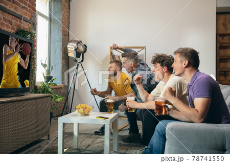 Group of friends watching TV, sport match together. Concept of friendship, leisure activity, emotions Group of friends watching TV, sport match together. Concept of friendship, leisure activity, emotions 78741550