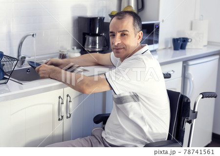 Young man Disabled Man On Wheelchair Washing Dishes 78741561
