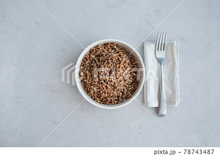 Bowl of buckwheat on a grey concrete background in minimalistic style. Concept of healthy food.  78743487
