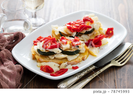 corn bread with cod fish and courgette on white dish 78745993