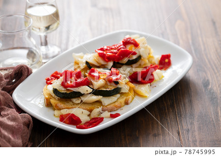 corn bread with cod fish and courgette on white dish 78745995