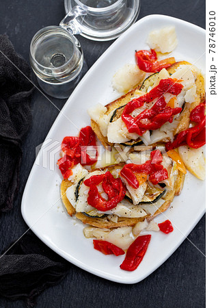 corn bread with cod fish and courgette on white dish 78746010