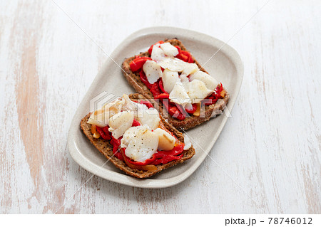 black healthy bread with cod fish and red pepper on dish 78746012