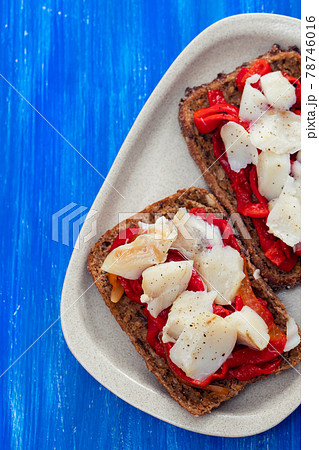 black healthy bread with cod fish and red pepper on dish 78746016