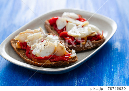 black healthy bread with cod fish and red pepper on dish 78746020
