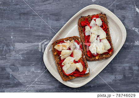 black healthy bread with cod fish and red pepper on dish 78746029