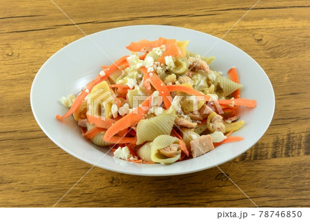 Cold salmon pasta dish with carrots and feta cheese and Greek feta cheese salad dressing on white bowl Cold salmon pasta dish with carrots and feta cheese and Greek feta cheese salad dressing on white bowl 78746850