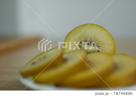 Slices of golden kiwi with yellow pulp on white plate on the kitchen. Exotic fruits, healthy eating concept 78746880