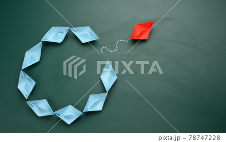 group of blue paper boats are sailing in one direction, one red is sailing in the opposite direction group of blue paper boats are sailing in one direction, one red is sailing in the opposite direction 78747228