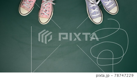 two pairs of textile sneakers on a green background. The concept of choosing a path is difficult and confusing or straight and easy 78747229