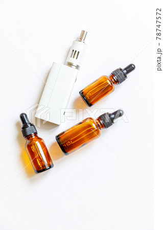 Vaping device e-cigarette electronic cigarette and liquid bottles isolated on white background. Vape device for alternative smoking. Vaping shop concept. Gadget for vaper. Vaping accessories. 78747572