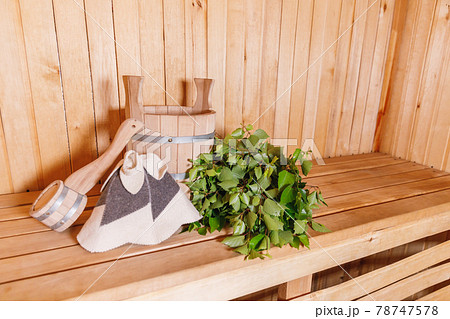 Traditional old Russian bathhouse SPA Concept. Interior details Finnish sauna steam room with traditional sauna accessories basin birch broom scoop felt. Relax country village bath concept. 78747578