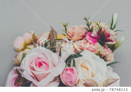 Bouquet of artificial pastel color flowers on gray background, top view with copy space Bouquet of artificial pastel color flowers on gray background, top view with copy space 78748213