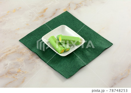 Melon and lime chewy candy pieces in white candy dish on green paper napkin Melon and lime chewy candy pieces in white candy dish on green paper napkin 78748253