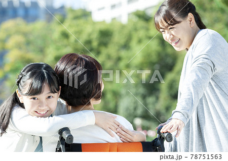 車椅子に座る祖母に抱きつく孫娘 車椅子に座る祖母に抱きつく孫娘 78751563