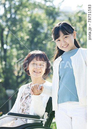 車椅子に座る祖母と笑顔の孫娘 78751583