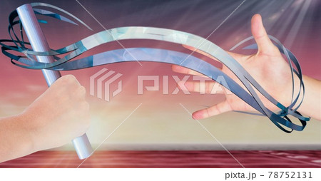 Composition of caucasian athletes passing grey relay baton with blue trails and glowing light Composition of caucasian athletes passing grey relay baton with blue trails and glowing light 78752131