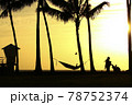 浜辺で眺める夕陽 78752374