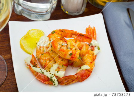Split fried prawns with lemon and parsley on a white plate Split fried prawns with lemon and parsley on a white plate 78758573