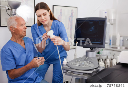 Portrait of young technician showing new ultrasound scan to doctor in clinic Portrait of young technician showing new ultrasound scan to doctor in clinic 78758841