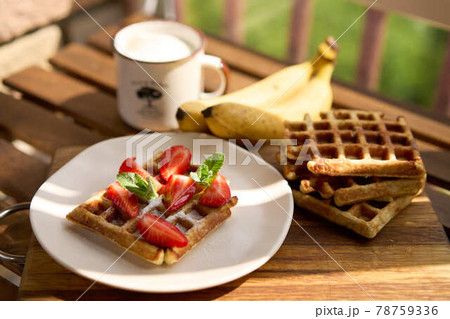 Closeup view of breakfast belgium waffles with strawberry and banana with mint on wooden background 78759336