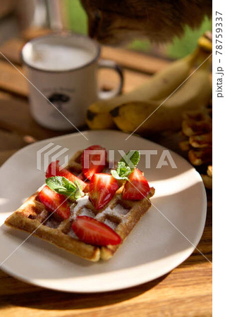 Closeup view of breakfast belgium waffles with strawberry and banana with mint on wooden background 78759337