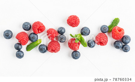 Fresh blueberries and raspberries plate on white background top view. 78760334