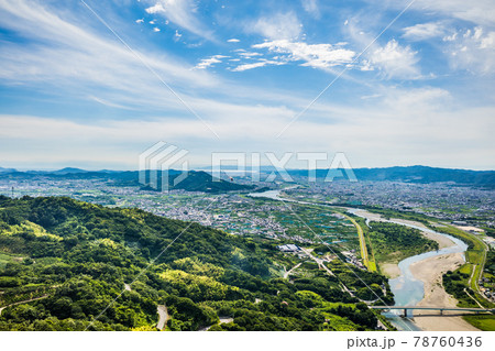 梅雨晴れの中、紀の川上空を飛ぶパラグライダーから和歌山市街と和歌山湾を望む 78760436