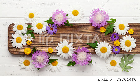 Various garden flowers over wooden background 78761486