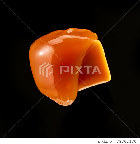 caramel sauce flowing on flying caramel candy 78762170