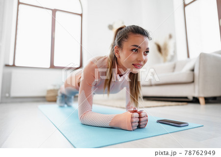 Sporty young woman doing plank exercise indoors at home 78762949