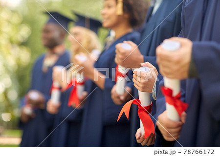 graduate students in mortar boards with diplomas graduate students in mortar boards with diplomas 78766172
