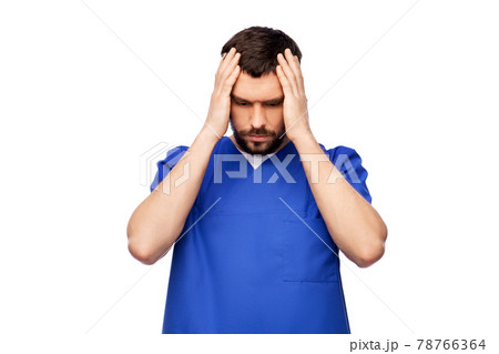 stressed doctor or male nurse in blue uniform stressed doctor or male nurse in blue uniform 78766364