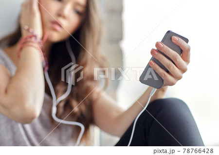 teenage girl with smartphone and earphones teenage girl with smartphone and earphones 78766428