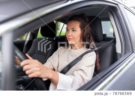 woman or female driver driving car in city 78766569