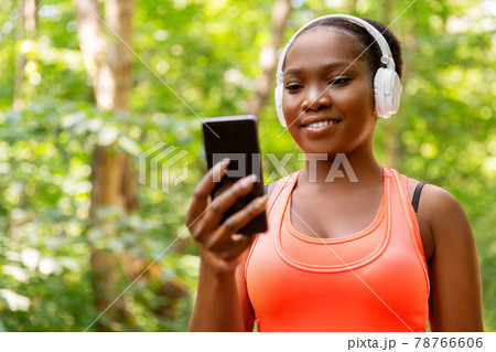 african american woman with headphones and phone 78766606