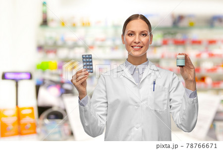 smiling female doctor holding medicine at pharmacy smiling female doctor holding medicine at pharmacy 78766671