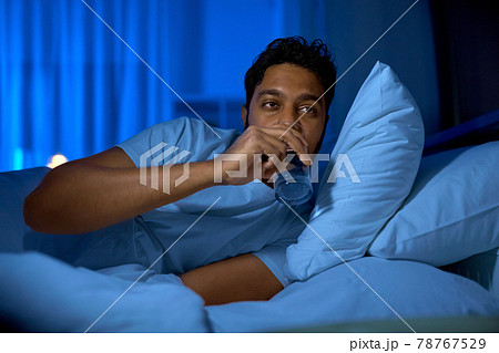 indian man drinking water in bed at night indian man drinking water in bed at night 78767529