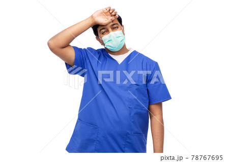 tired indian male doctor in blue uniform and mask 78767695