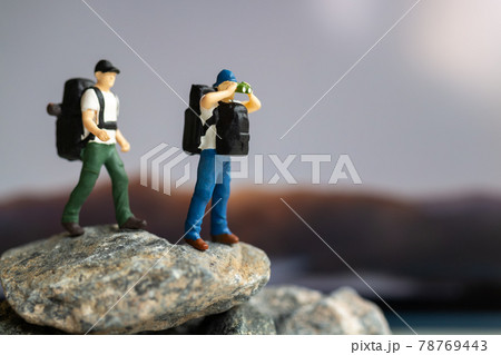 Miniature people : Traveler with backpack walking on the rock Miniature people : Traveler with backpack walking on the rock 78769443