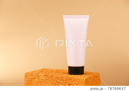 Unbranded light pink squeeze bottle plastic tube with black screw cap on golden podium on gold background. Front view, mockup. Natural organic spa cosmetic. Copy space Unbranded light pink squeeze bottle plastic tube with black screw cap on golden podium on gold background. Front view, mockup. Natural organic spa cosmetic. Copy space 78769637