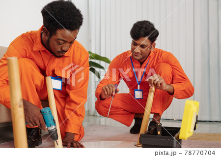 Team of handymen assembling table 78770704