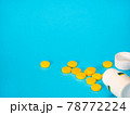 Yellow pills and plastic white bottle 78772224