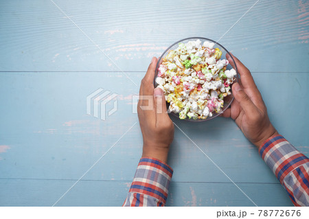 young man eating popcorn top view young man eating popcorn top view 78772676