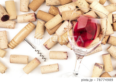 Glass of red wine with corks and corkscrew on a white background 78774989