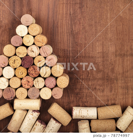 A Christmas tree made of wine corks on a dark rustic wooden background 78774997