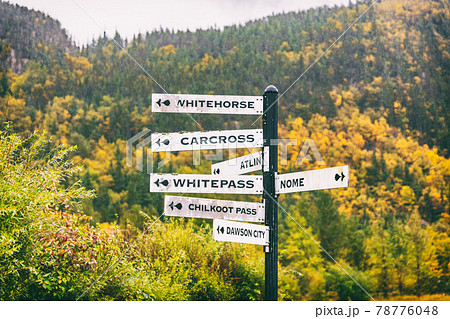 Alaska tourist street signs showing directions of different nearest tourism cities destination. Chilkoot, Whitehorse, Juneau, Skagway. Road sign in Skagway city. 78776048